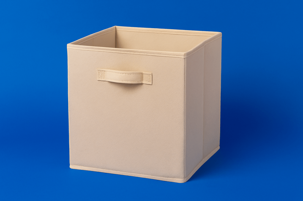 Beige fabric collapsible storage cube with handle on a royal blue background